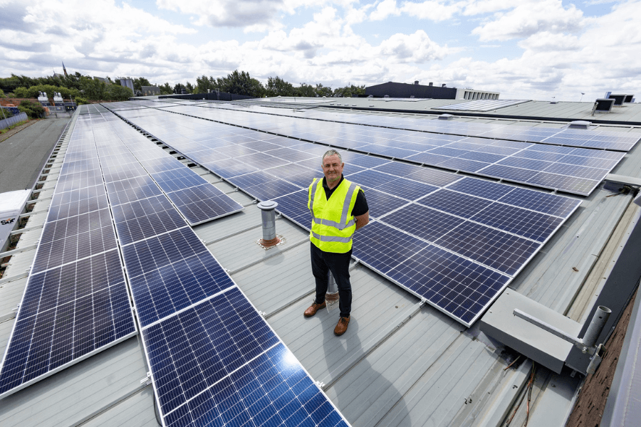 Antony Grace, one of the directors of ASH Integrated Services stood on a roof covered with solar panels