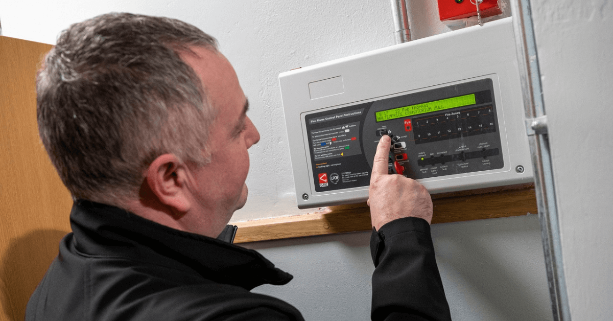 Antony Grace from ASH Integrated Services using an electronic control panel on a wall