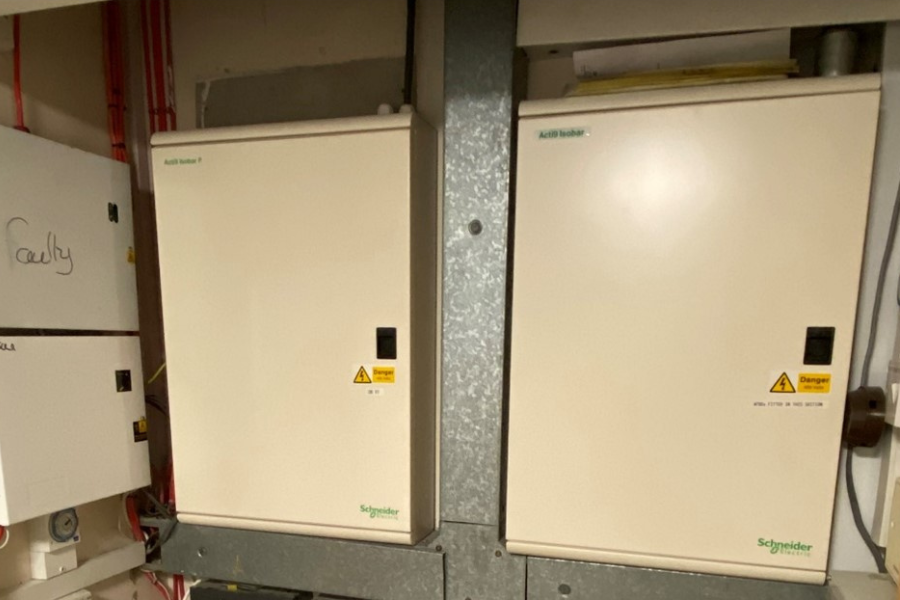 two electrical distribution boards in a room with electrical wires attached to them
