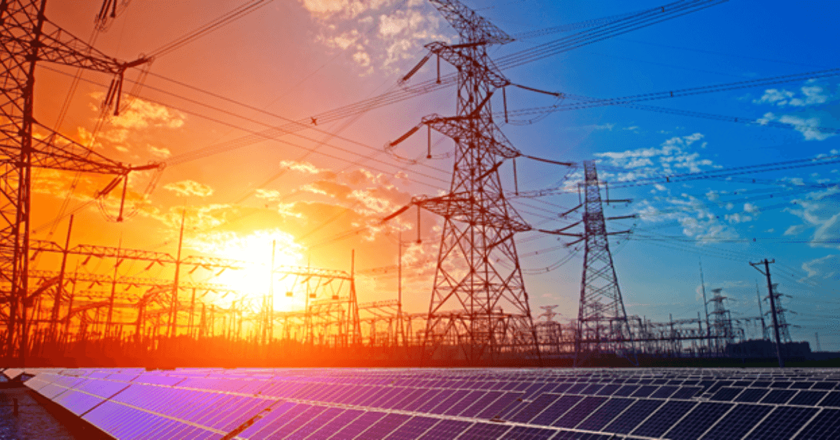 solar panels and electricity pylons at sunset