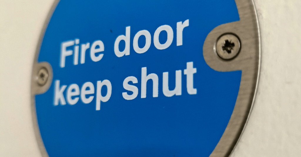 a blue and white sign that says fire door keep shut