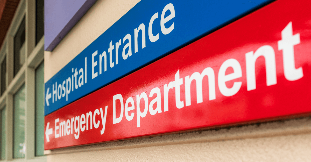 a red, blue and white emergency department sign on the side of a building