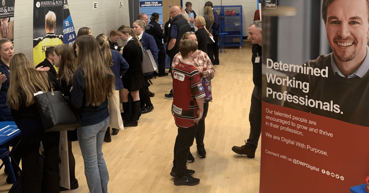 a large group of people standing around in a gymnasium at a careers fair