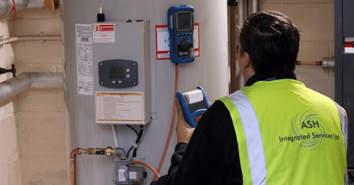 a person in a safety vest checking the temperature of a water heater