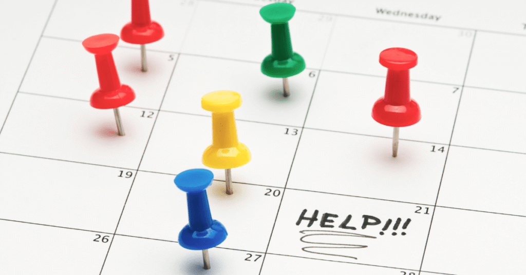 colorful push pins on a calendar with the word help written on it