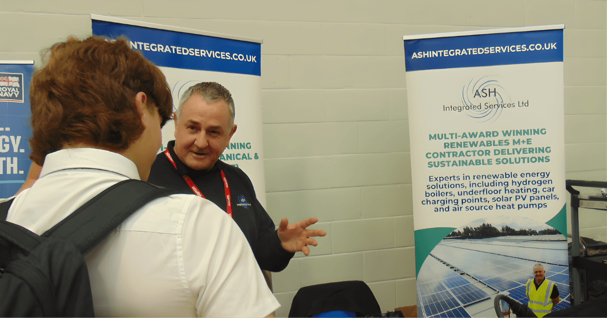 a man talking to another man at a trade show