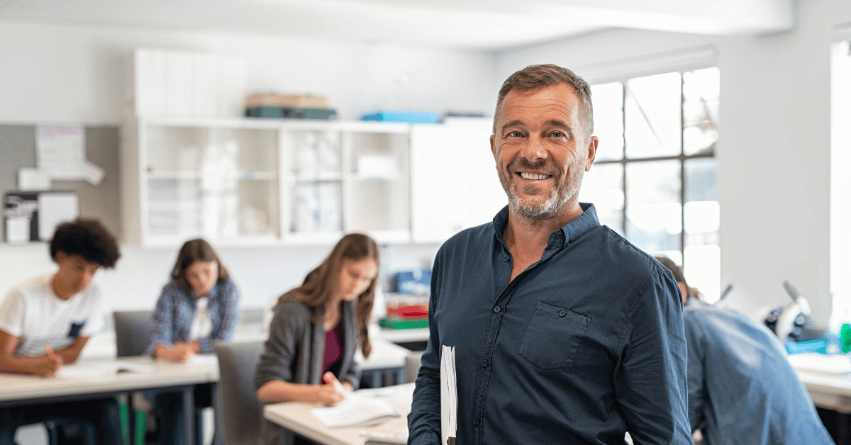 Mature male learner smiling, wearing a dark blue shirt