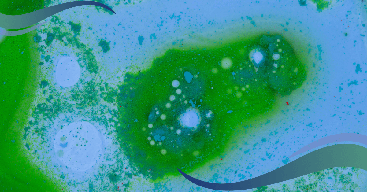 An abstract image of swirling green and blue liquids with small white and blue bubbles and speckles.