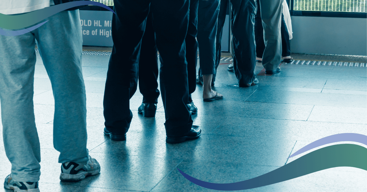 Image shows peoples legs waiting in line