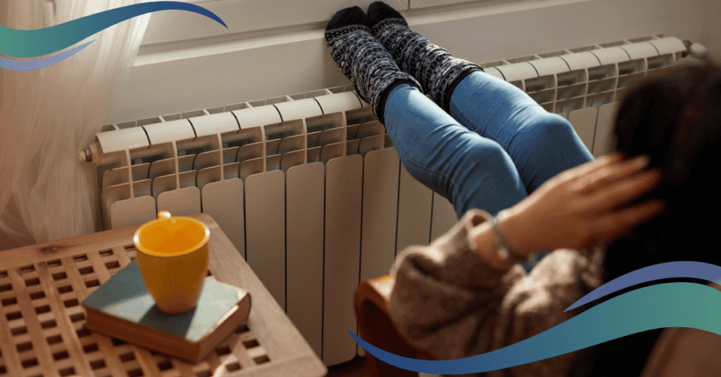 Image shows a lady sat with thick socks on with her feet up on a radiator